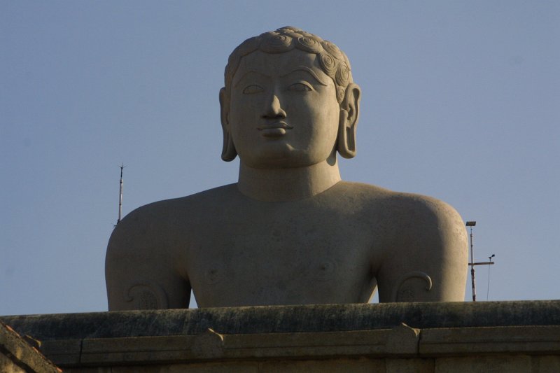 1534000_HeadOfNakedManSriGomatheswarKarnataka.jpg - Bahubali statue looking over the temple wall. Sharavanabelagola.