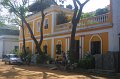 1899000_ManRefinishingFurnitureOutsideGuestHouse